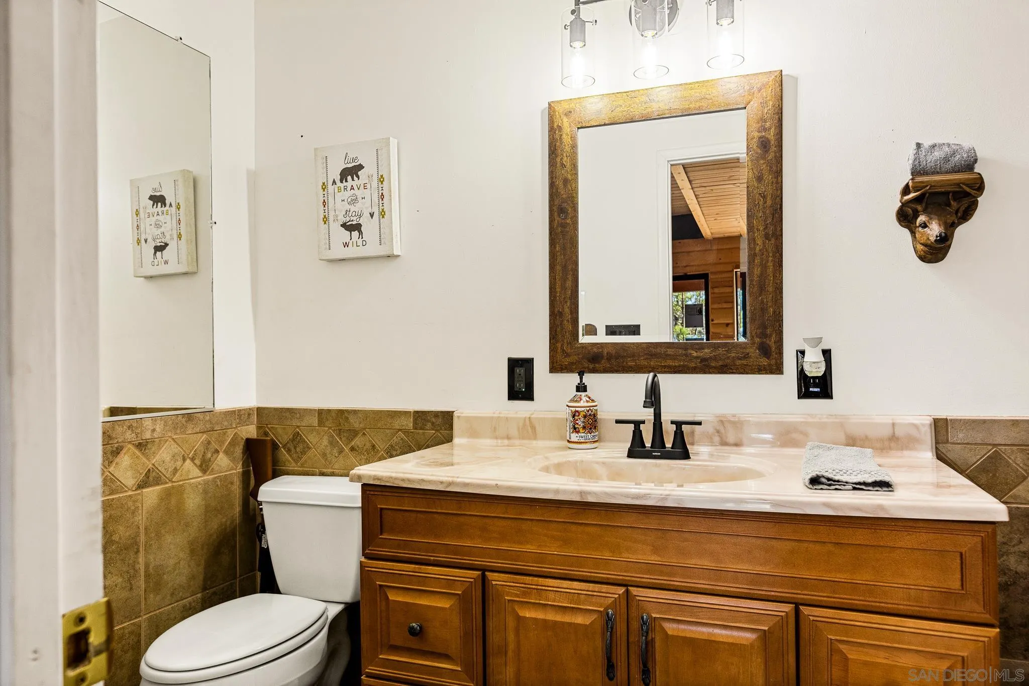 683 Grass Valley Road Lake Arrowhead, CA 92352 - Photo 34 of 39 a bathroom with a toilet sink vanity and mirror