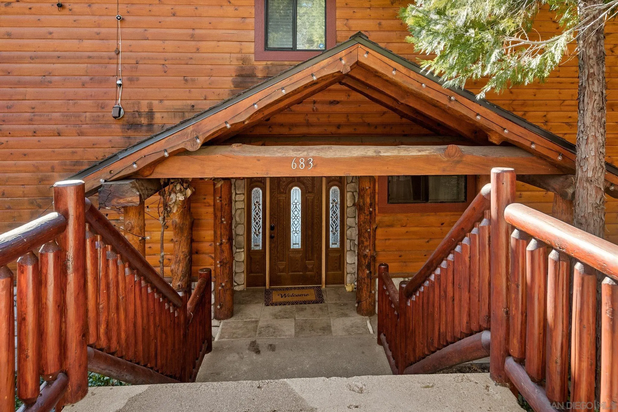 683 Grass Valley Road Lake Arrowhead, CA 92352 - Photo 6 of 39 a front view of a house with wooden stairs