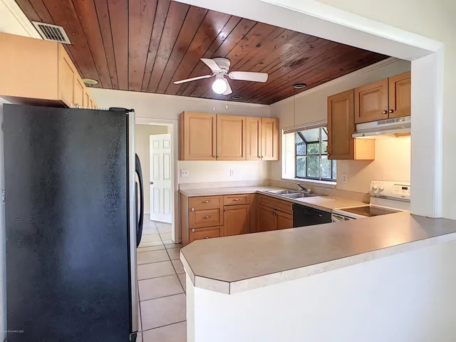 a kitchen with stainless steel appliances granite countertop a sink refrigerator and window