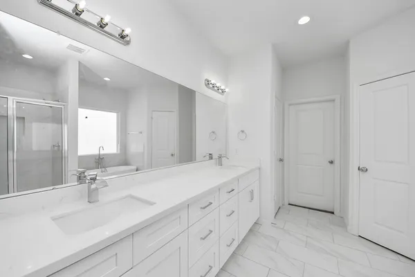 a spacious bathroom with a double vanity sink mirror and double