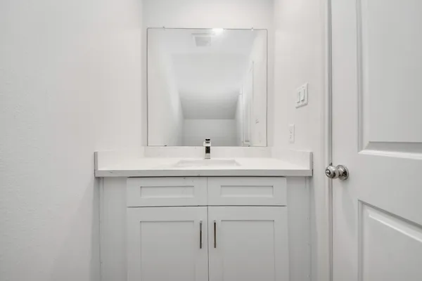 a bathroom with a sink vanity and a mirror