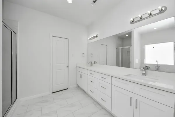 a bathroom with double sink and a mirror