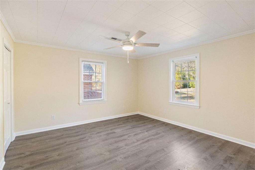 614 Burnett Ferry Road Southwest Rome, GA 30165 - Photo 9 of 29 an empty room with wooden floor ceiling fan and windows