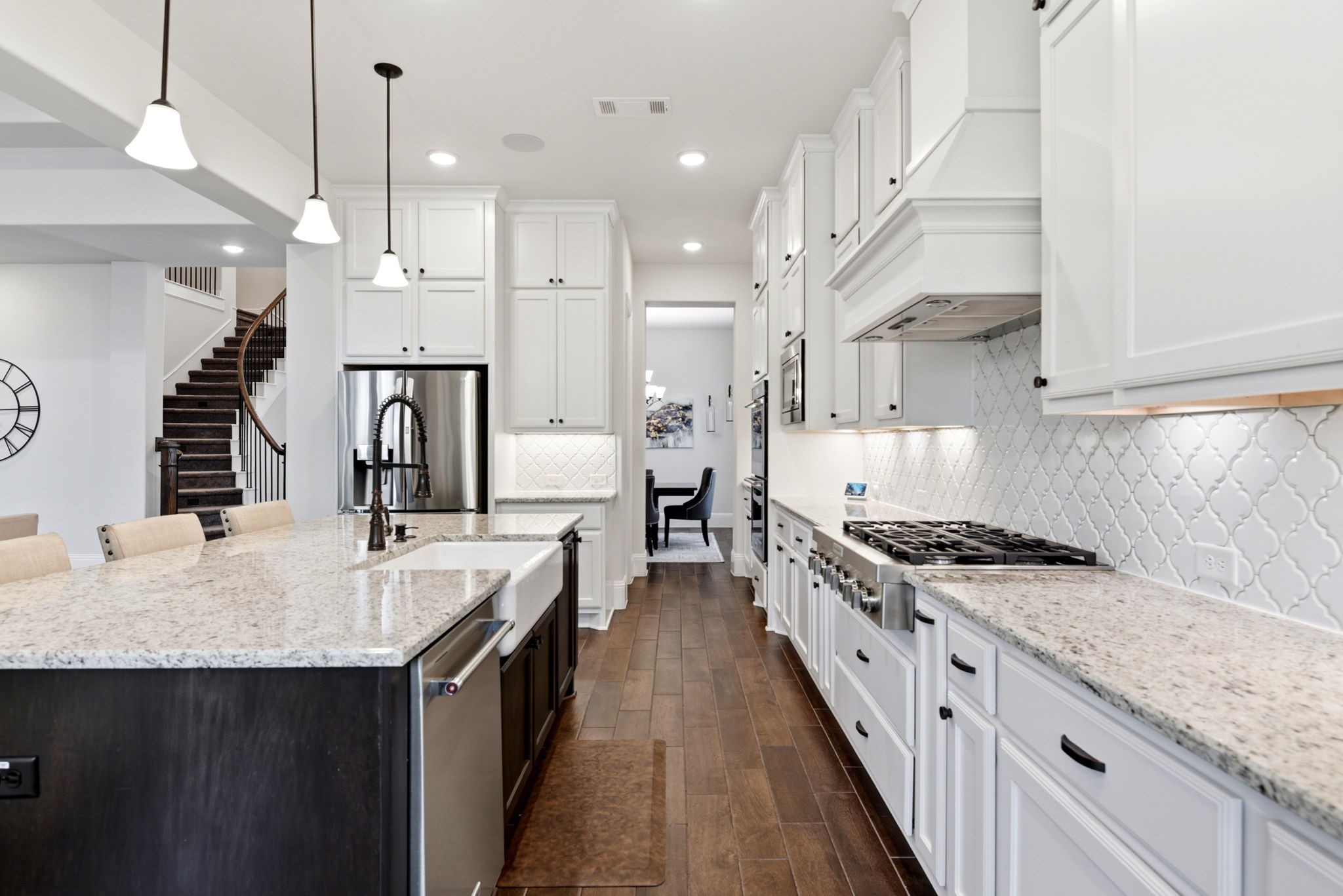 10062 South Goshawk Trail Conroe, TX 77385 - Photo 13 of 43 a large kitchen with stainless steel appliances kitchen island granite countertop a sink a stove and a wooden floors