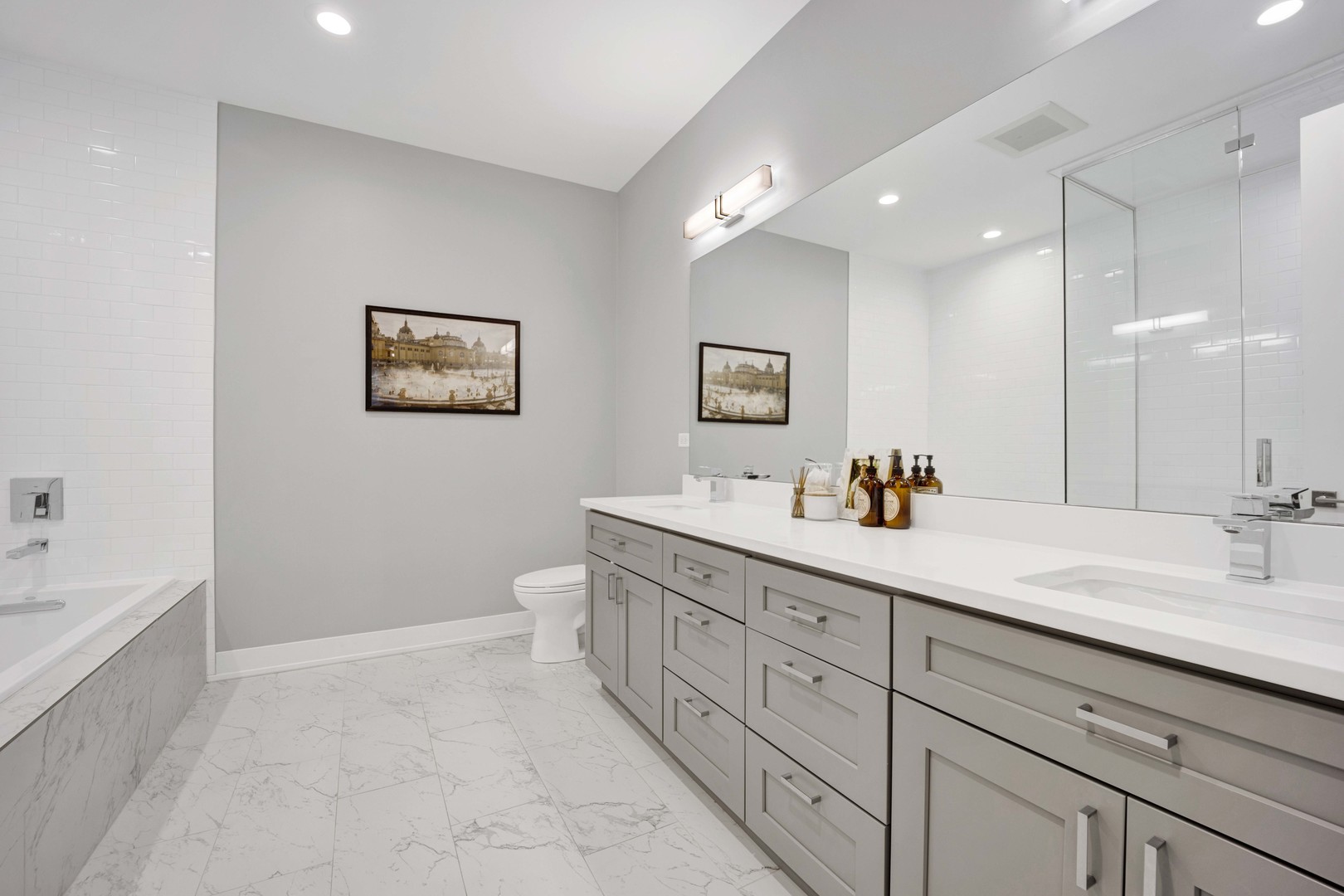 2140 West Rice Street, Unit 1W Chicago, IL 60622 - Photo 13 of 25 a spacious bathroom with a double vanity sink a mirror and a bathtub