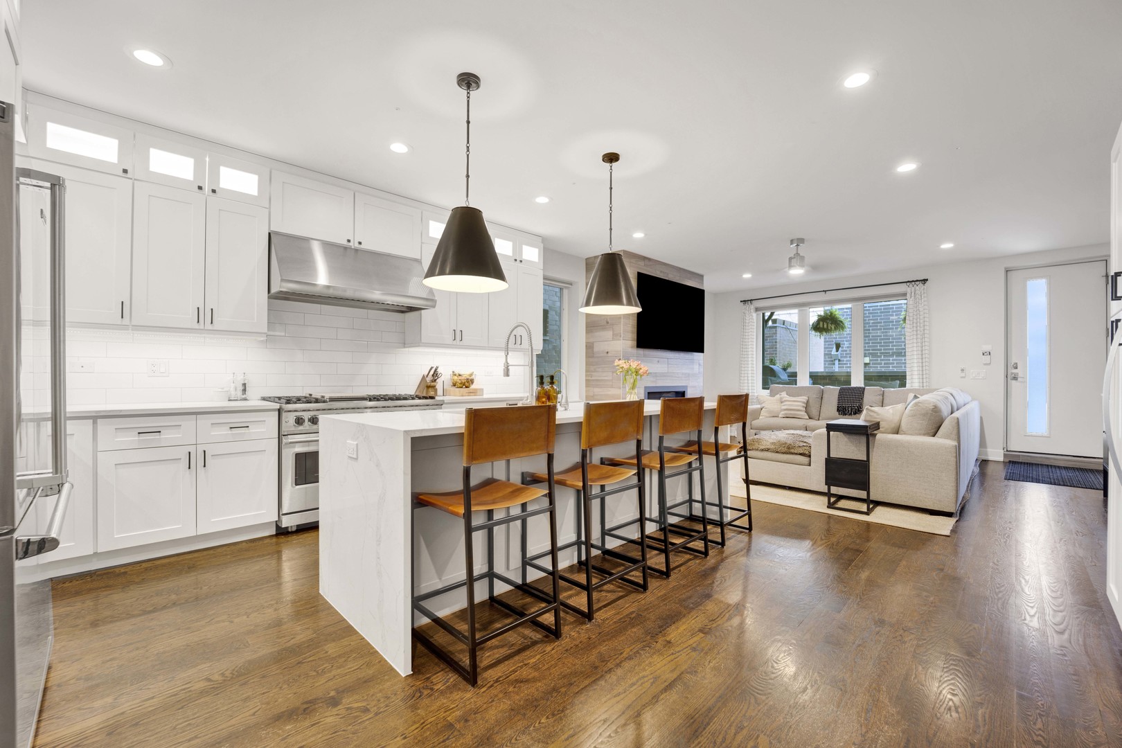 2140 West Rice Street, Unit 1W Chicago, IL 60622 - Photo 2 of 25 a kitchen with stainless steel appliances kitchen island granite countertop a stove top oven a sink a dining table and chairs with wooden floor