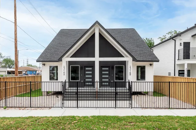 a view of a house with a small yard and wooden fence