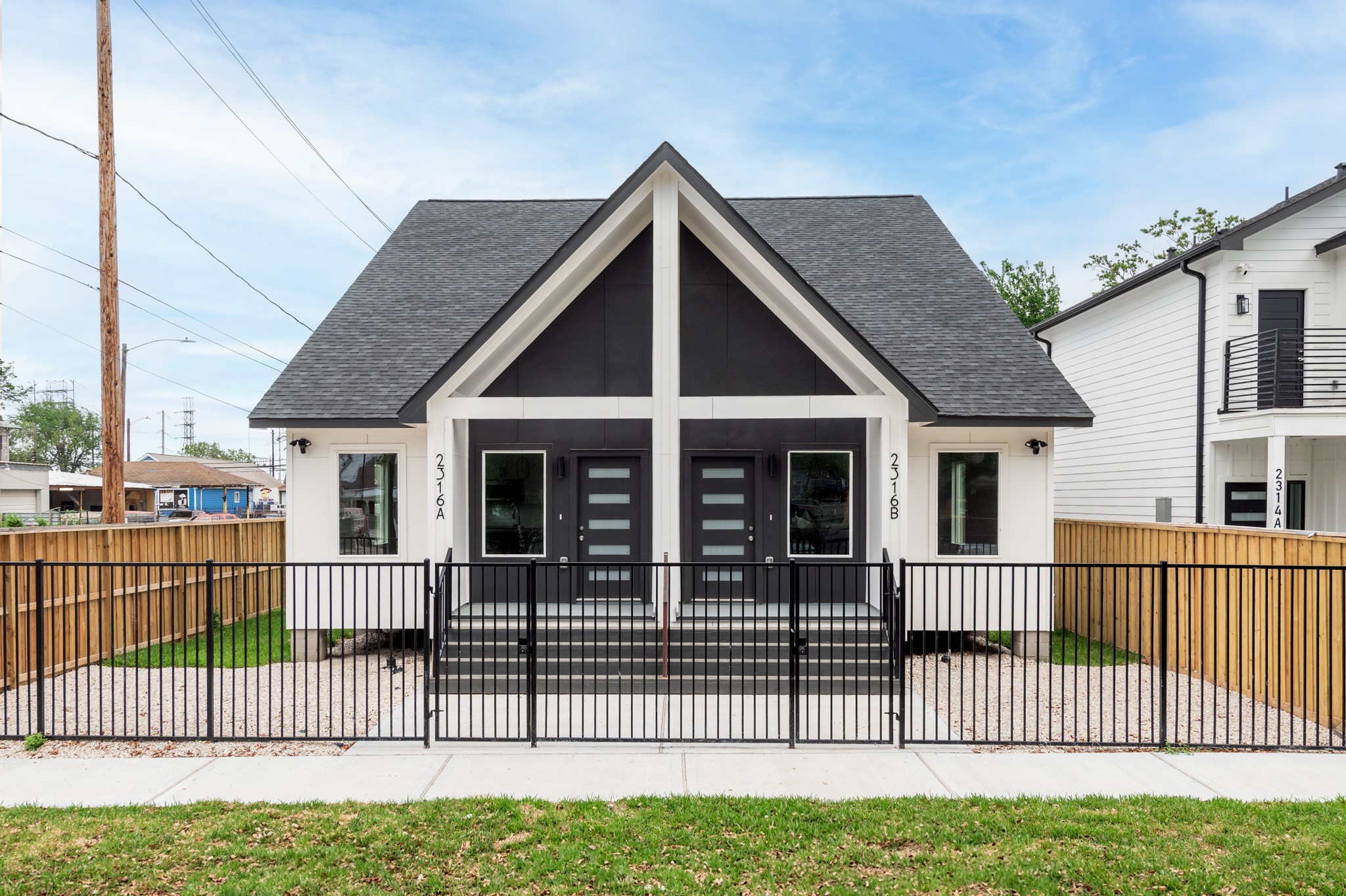 a view of a house with a small yard and wooden fence