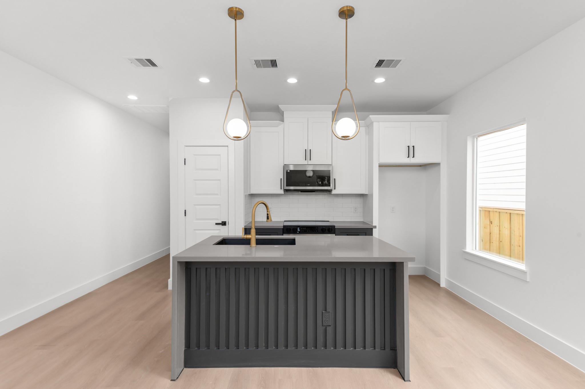 2316 McKee Street, Unit A Houston, TX 77009 - Photo 4 of 12 a kitchen with kitchen island granite countertop a sink a counter space appliances and a window