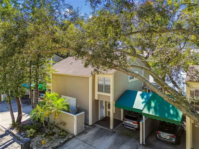 an aerial view of ocean and residential houses with outdoor space
