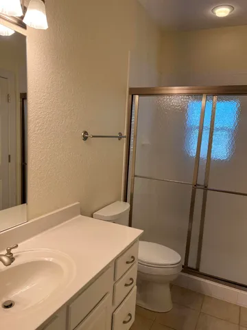 a bathroom with a sink a toilet a shower and a mirror