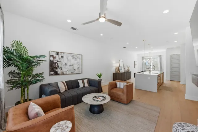 a living room with furniture and a dining table with kitchen view