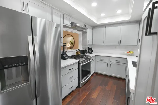 a kitchen with a refrigerator sink and cabinets