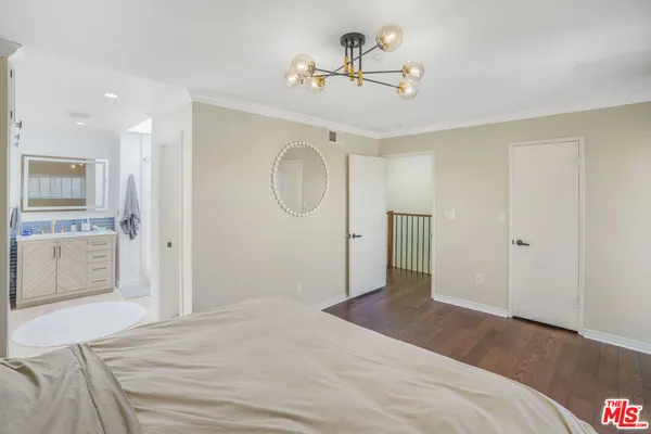 a bedroom with a bed and a chandelier