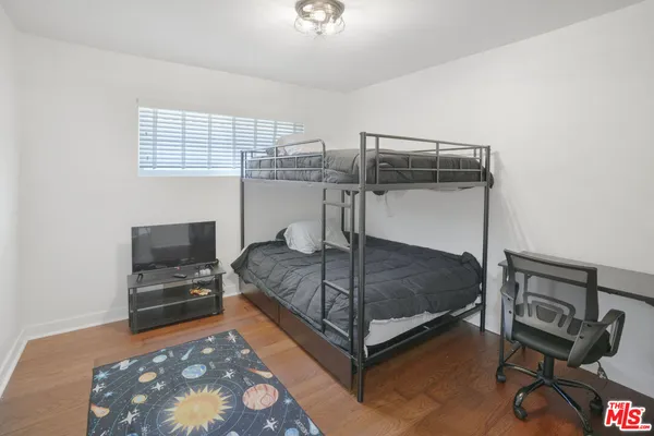 a bedroom with a bed and a tv on the dresser