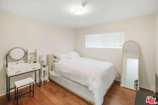 a bedroom with a bed a mirror and a table