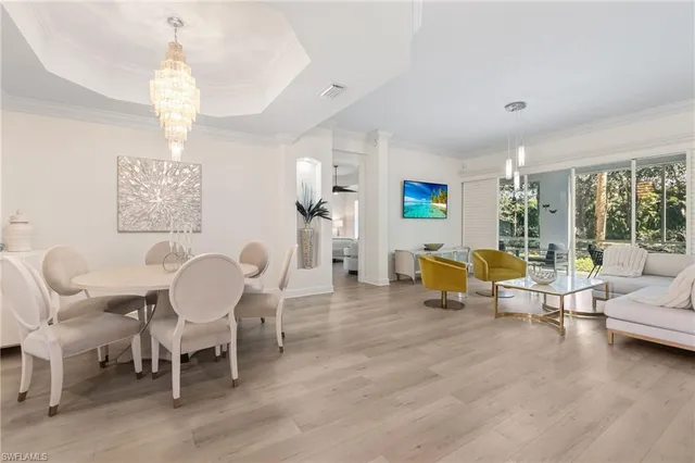 a living room with furniture chandelier and window