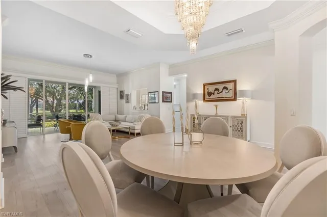 a living room with furniture a chandelier and a dining table