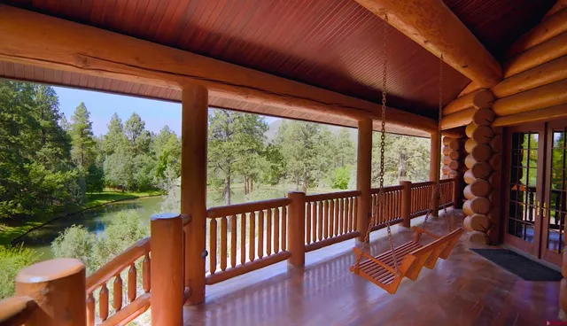 a view of a porch with wooden floor and outdoor seating