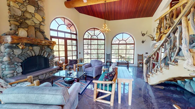 a living room with furniture a fireplace and a large window