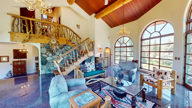 a living room with furniture a fireplace and a chandelier