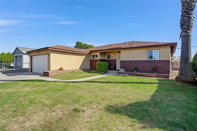 a view of a house with a yard and a large tree