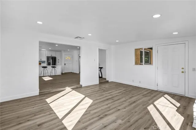 an empty room with wooden floor and a window