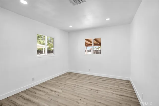 a view of an empty room with wooden floor