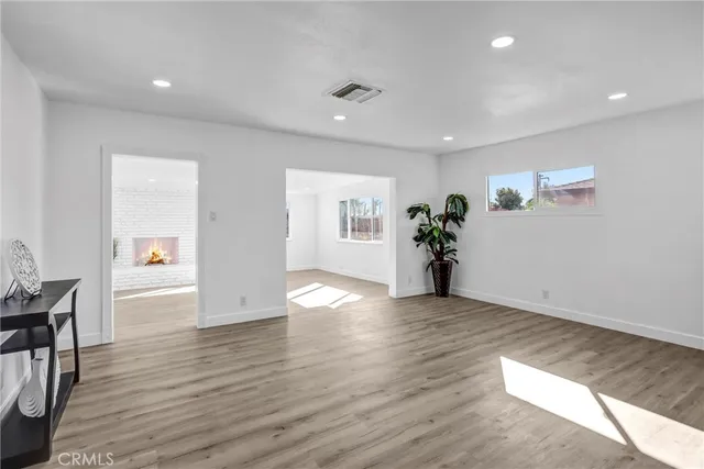 a view of a big room with wooden floor and windows
