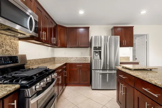 a kitchen with stainless steel appliances granite countertop a stove and a refrigerator