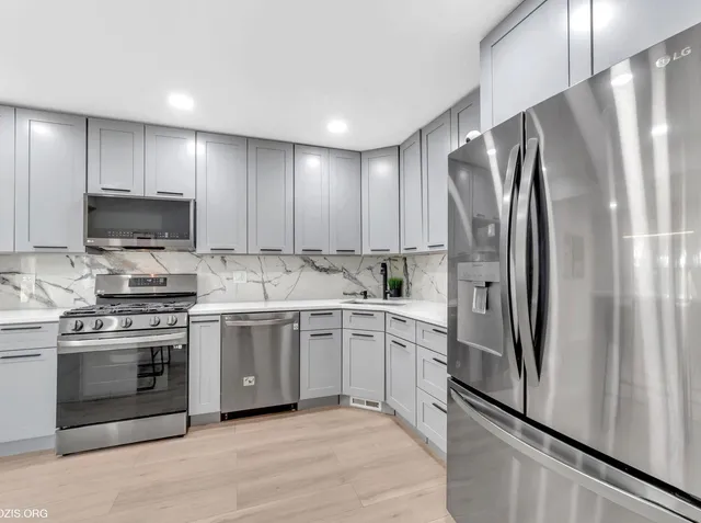 a kitchen with stainless steel appliances a refrigerator sink and stove