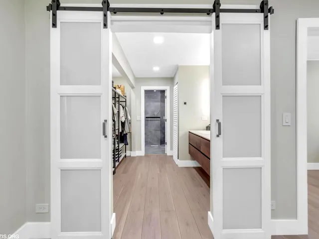 a view of a hallway with wooden floor and staircase