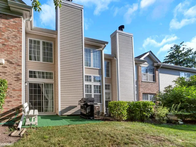 a front view of a house with a yard and potted plants
