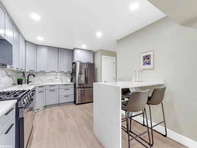 a kitchen with a refrigerator a stove top oven a sink dishwasher with wooden cabinets and dining table