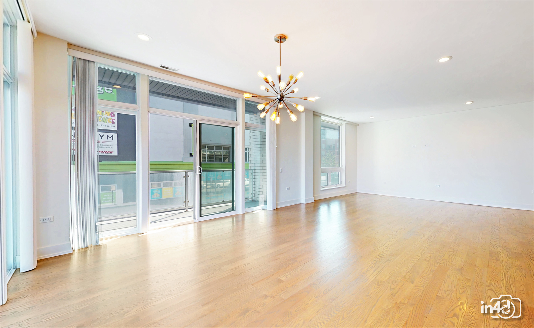 236 South Racine Avenue, Unit 201 Chicago, IL 60607 - Photo 20 of 45 a view of an empty room with chandelier fan and wooden floor
