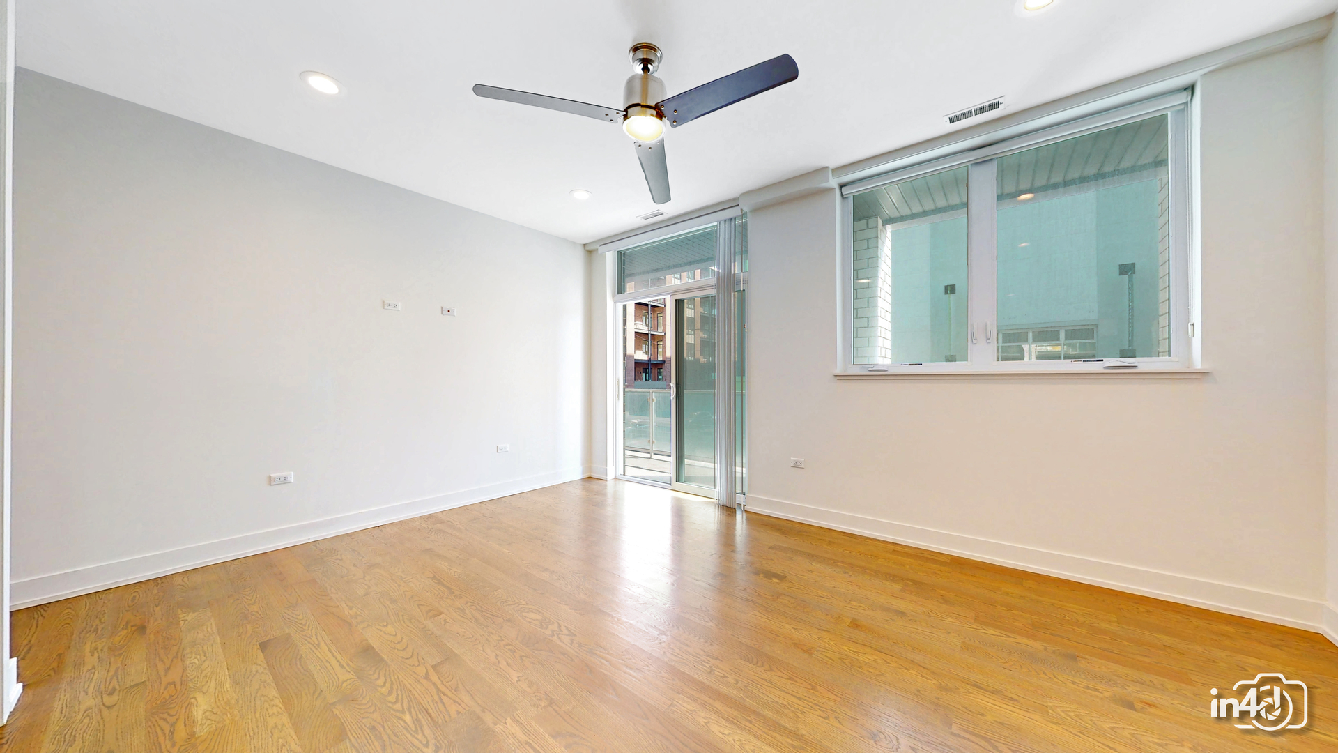 236 South Racine Avenue, Unit 201 Chicago, IL 60607 - Photo 37 of 45 an empty room with wooden floor a ceiling fan and windows
