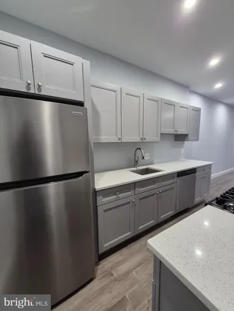 a kitchen with a refrigerator sink and cabinets