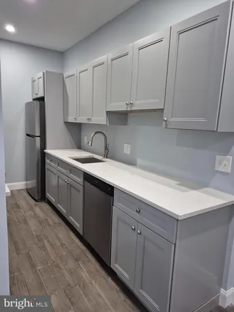 a kitchen with a sink dishwasher and a refrigerator
