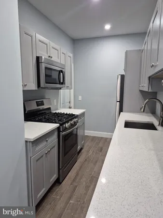 a kitchen with stainless steel appliances granite countertop a sink stove microwave and refrigerator