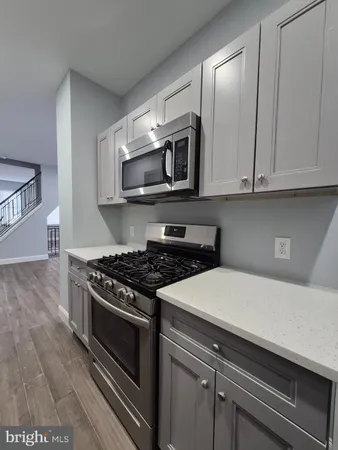 a kitchen with stainless steel appliances white cabinets and stove