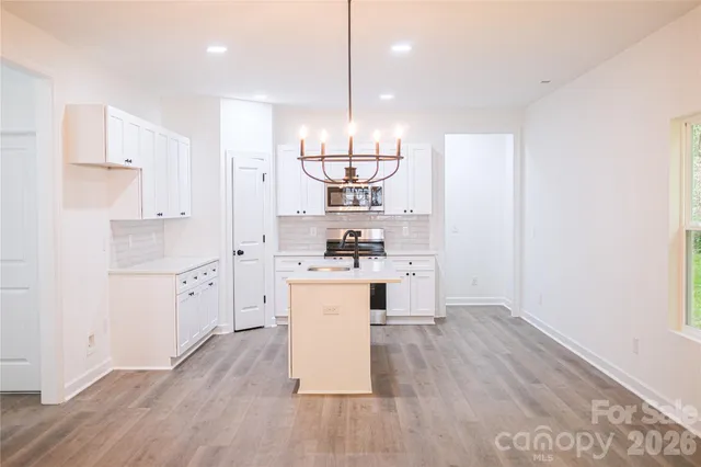 a kitchen with stainless steel appliances a refrigerator and wooden floor