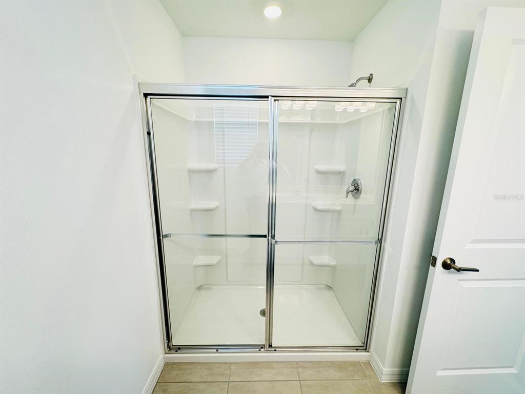 3140 Skyline Loop Kissimmee, FL 34758 - Photo 19 of 27 a bathroom with a glass shower door