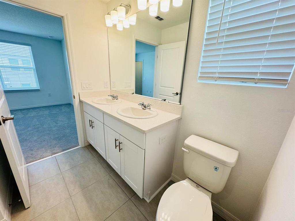 3140 Skyline Loop Kissimmee, FL 34758 - Photo 20 of 27 a spacious bathroom with a toilet sink and mirror