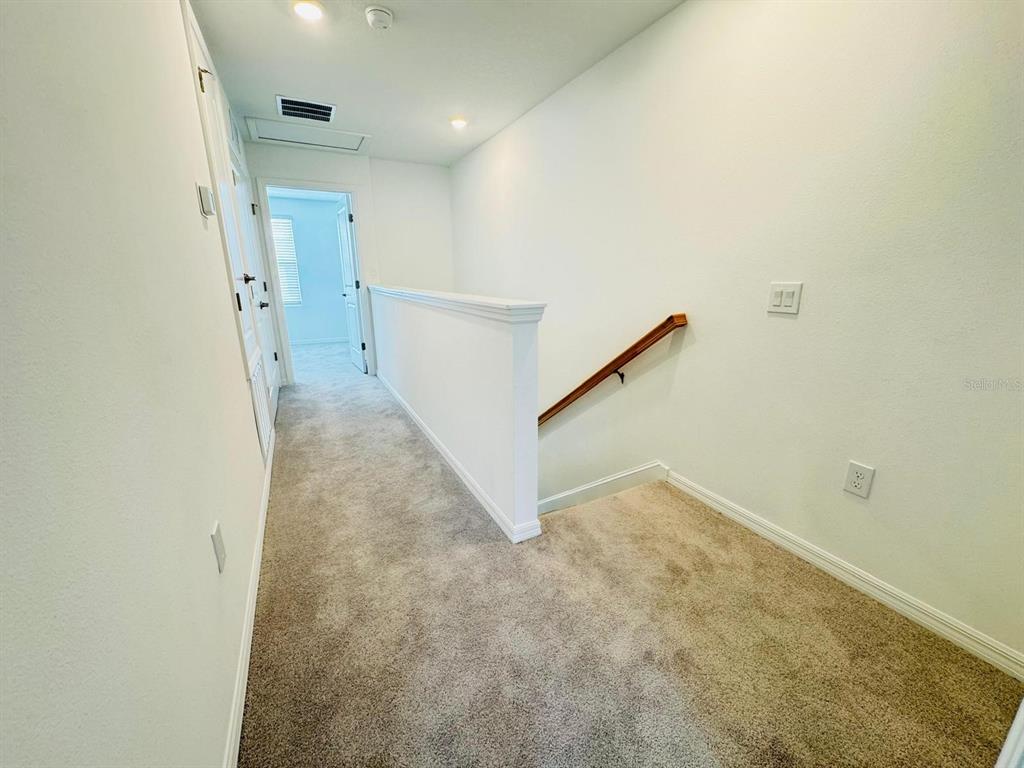 3140 Skyline Loop Kissimmee, FL 34758 - Photo 21 of 27 a view of a hallway with staircase