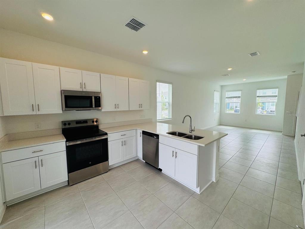 3140 Skyline Loop Kissimmee, FL 34758 - Photo 4 of 27 a kitchen with granite countertop a sink stove and cabinets