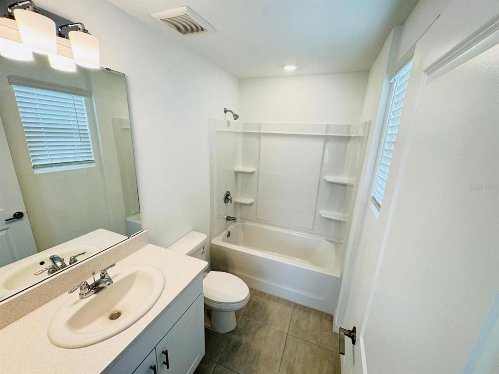 3140 Skyline Loop Kissimmee, FL 34758 - Photo 10 of 27 a bathroom with a sink a toilet and a bathtub