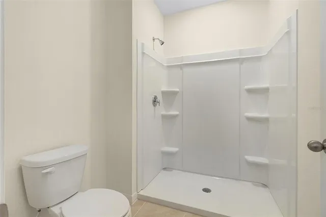 a bathroom with a toilet and a shower