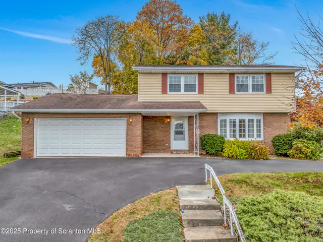 a front view of a house with a garden and yard
