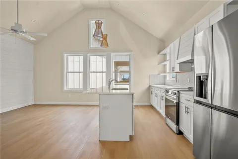 a kitchen with a refrigerator a sink and a stove top oven