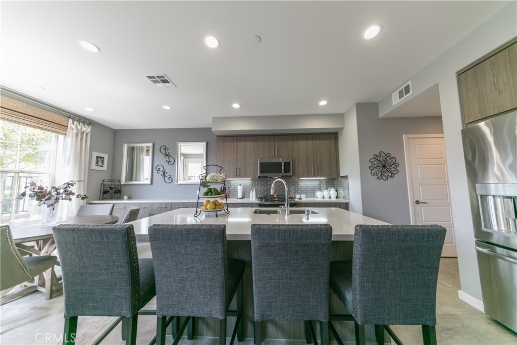308 Finch Lake Forest, CA 92630 - Photo 6 of 35 a dining area with stainless steel appliances kitchen island granite countertop a dining table chairs and a refrigerator
